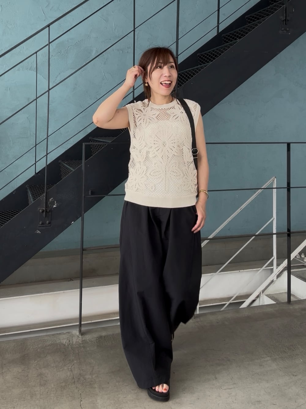 ブラック系のその他パンツ、ブラック系のサンダル、ベージュ系のニット/セーターを着用したレディースの夏コーディネートの1枚目の写真