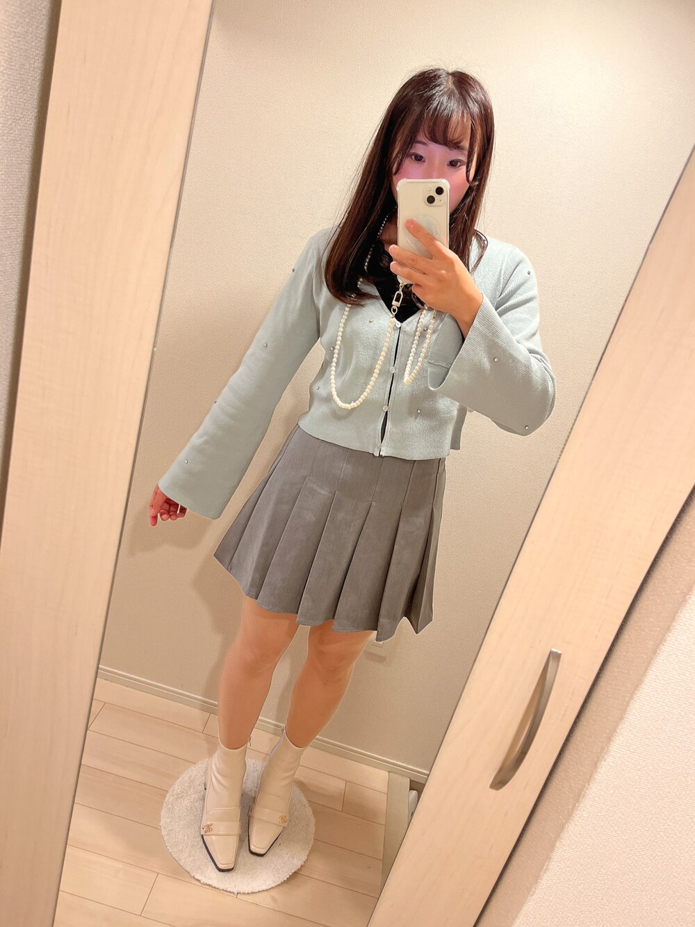 グレー系のその他パンツ、グリーン系のカーディガン/ボレロ、ホワイト系のブーツを着用したレディースの秋コーディネートの1枚目の写真