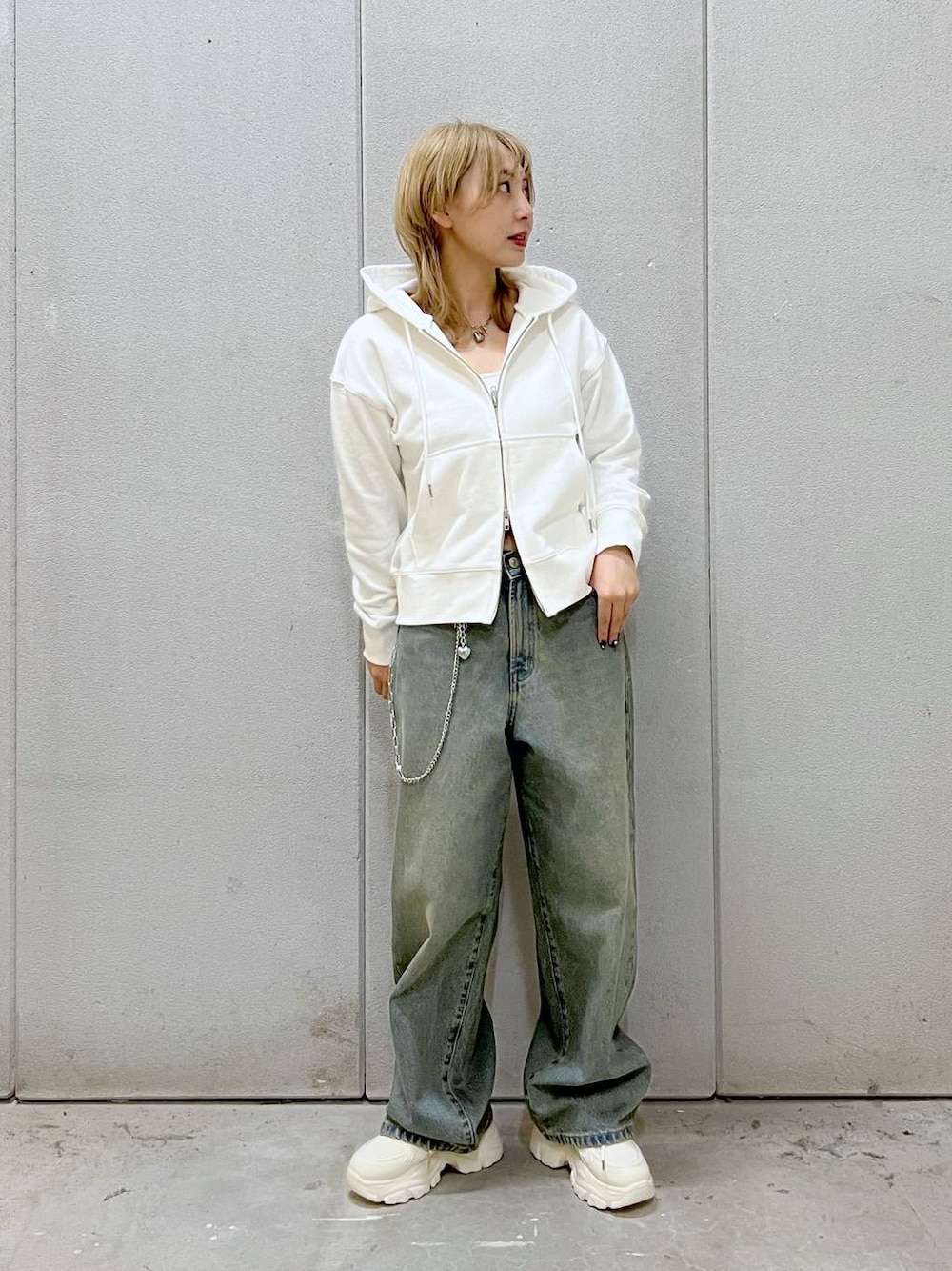 ブルー系のデニムパンツ、ホワイト系のスニーカー、ホワイト系のTシャツ/カットソーを着用したレディースの秋コーディネートの1枚目の写真