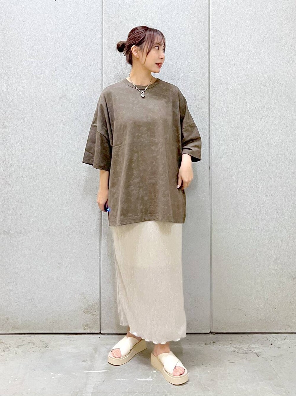 ホワイト系のスカート、ホワイト系のサンダル、ブラウン系のTシャツ/カットソーを着用したレディースの夏コーディネートの1枚目の写真