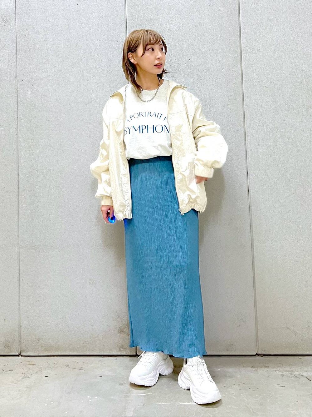 ブルー系のスカート、ホワイト系のスニーカー、グレー系のTシャツ/カットソーを着用したレディースの冬コーディネートの1枚目の写真