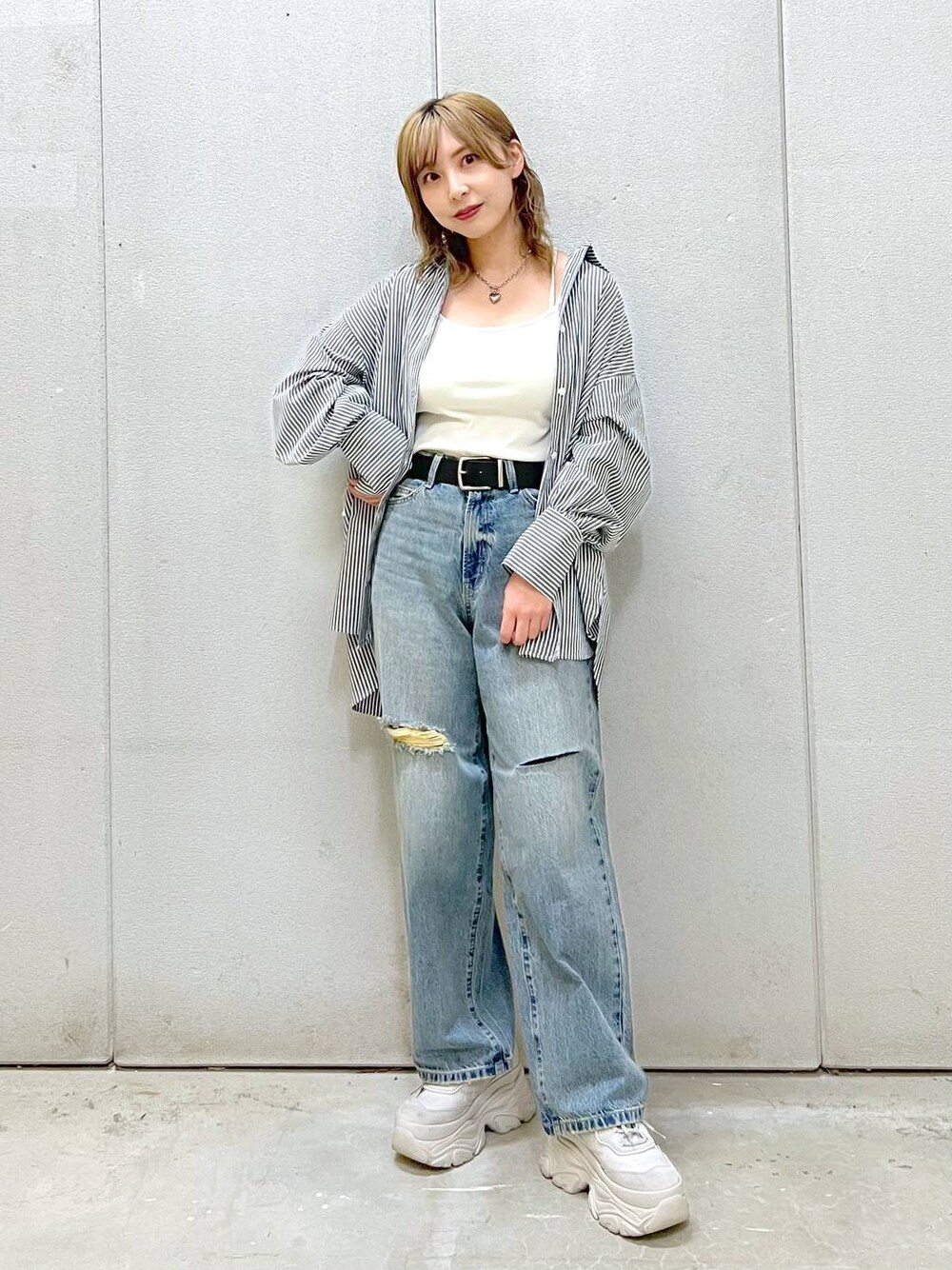 ホワイト系のTシャツ/カットソー、グレー系のスニーカー、ブルー系のデニムパンツを着用したレディースの春コーディネートの1枚目の写真