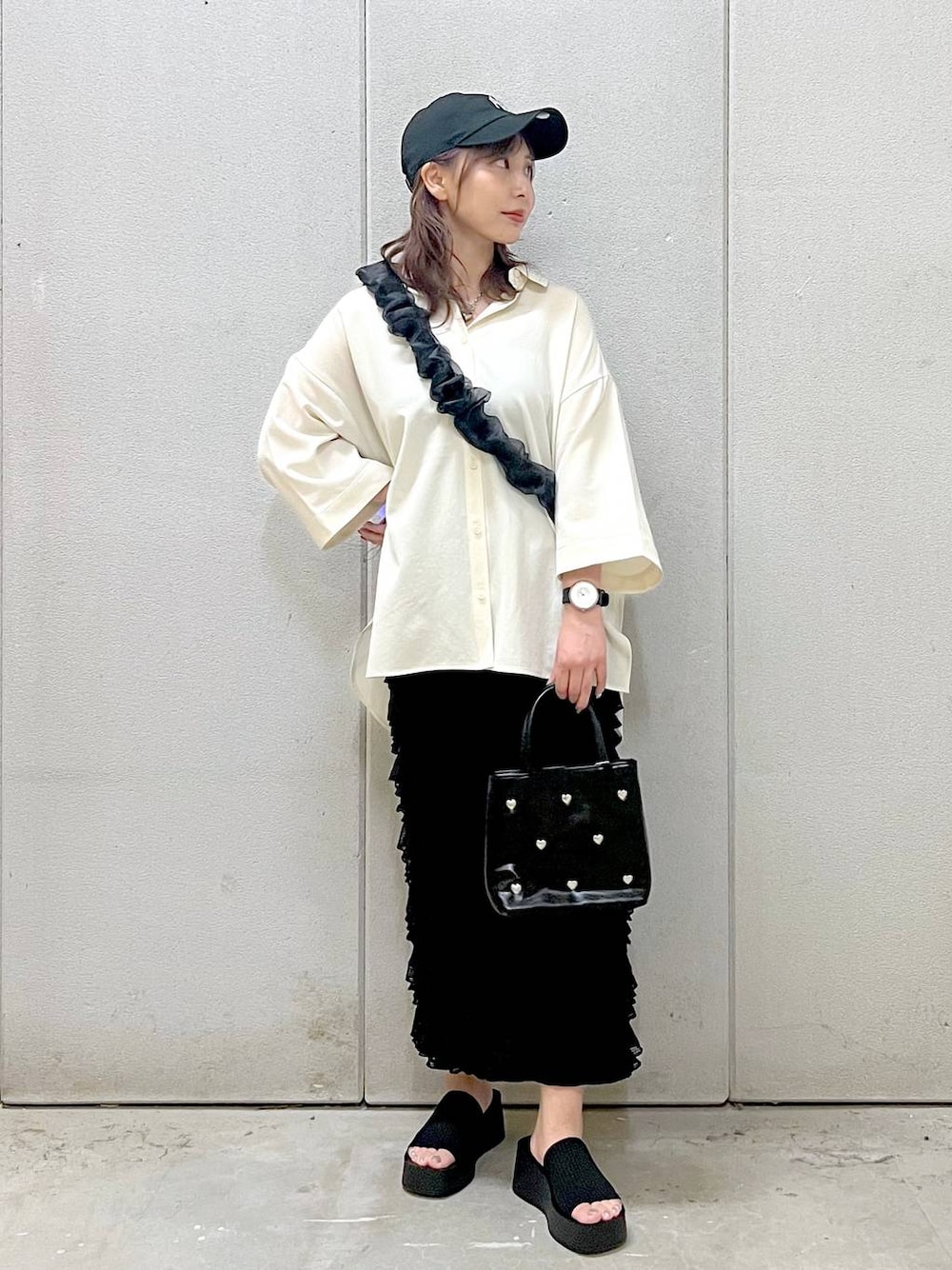 ブラック系のサンダル、グレー系のスカート、ホワイト系のシャツ/ブラウスを着用したレディースの夏コーディネートの1枚目の写真