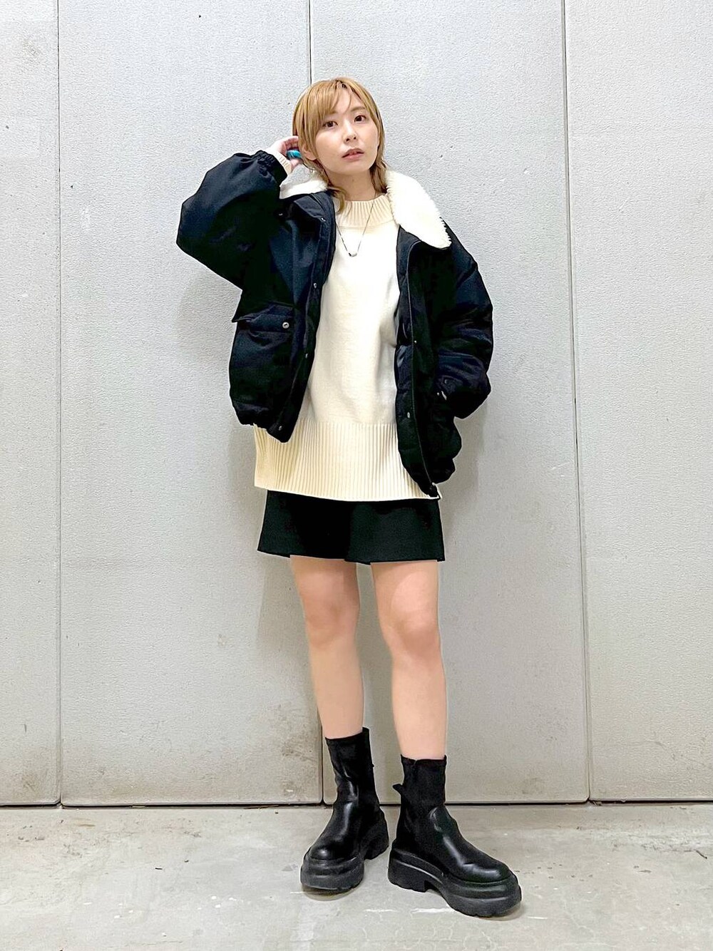 ホワイト系のニット/セーター、ブラック系のその他パンツ、ブラック系のブーツを着用したレディースの冬コーディネートの1枚目の写真