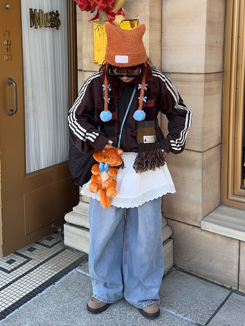 ブルー系のデニムパンツ、ブラウン系のジャージ、ホワイト系のスカートを着用したレディースの冬コーディネートの1枚目の写真