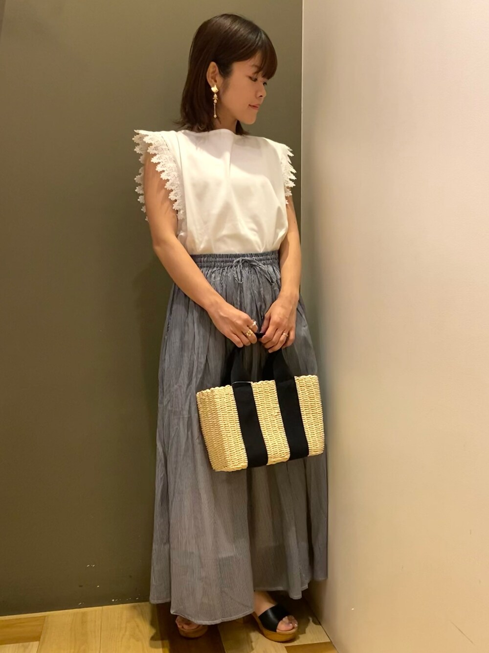 ホワイト系のTシャツ/カットソー、その他のスカート、ブラック系のハンドバッグを着用したレディースの夏コーディネートの1枚目の写真