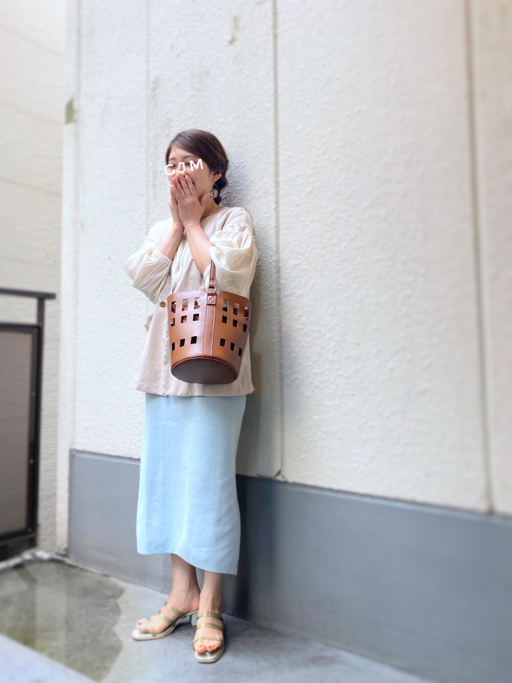 ブルー系のスカート、グリーン系のサンダル、ブラウン系のバッグを着用したレディースの春コーディネートの1枚目の写真