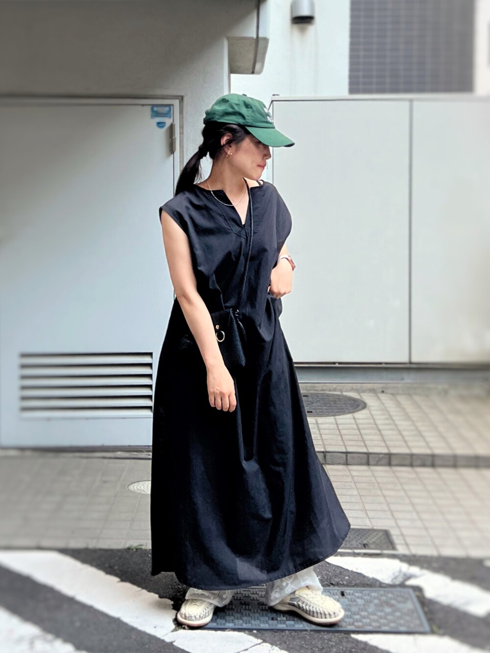 ホワイト系のサンダル、ブラック系のワンピース、ブラック系のショルダーバッグを着用したレディースの夏コーディネートの1枚目の写真