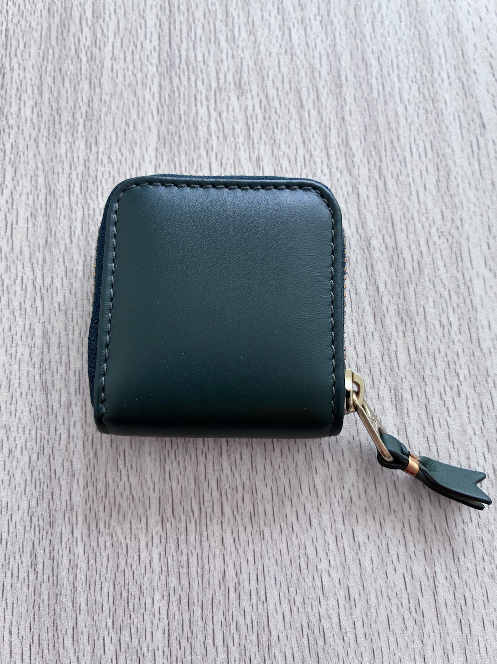 グリーン系のコインケースを着用したレディースの冬コーディネートの1枚目の写真