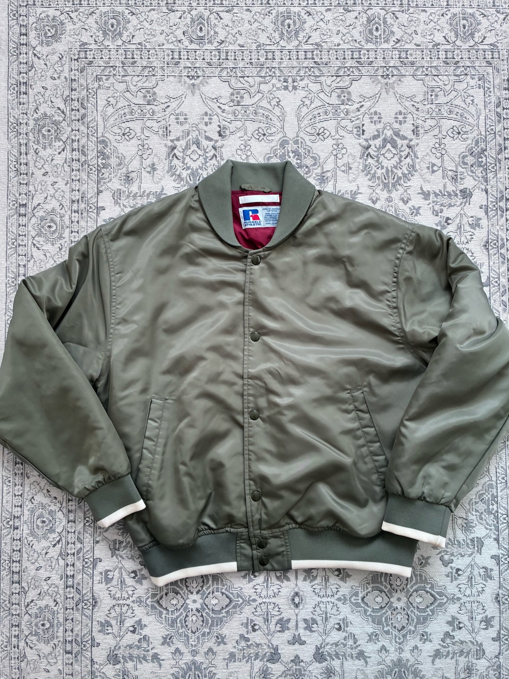 グリーン系のブルゾンを着用したレディースの冬コーディネートの1枚目の写真