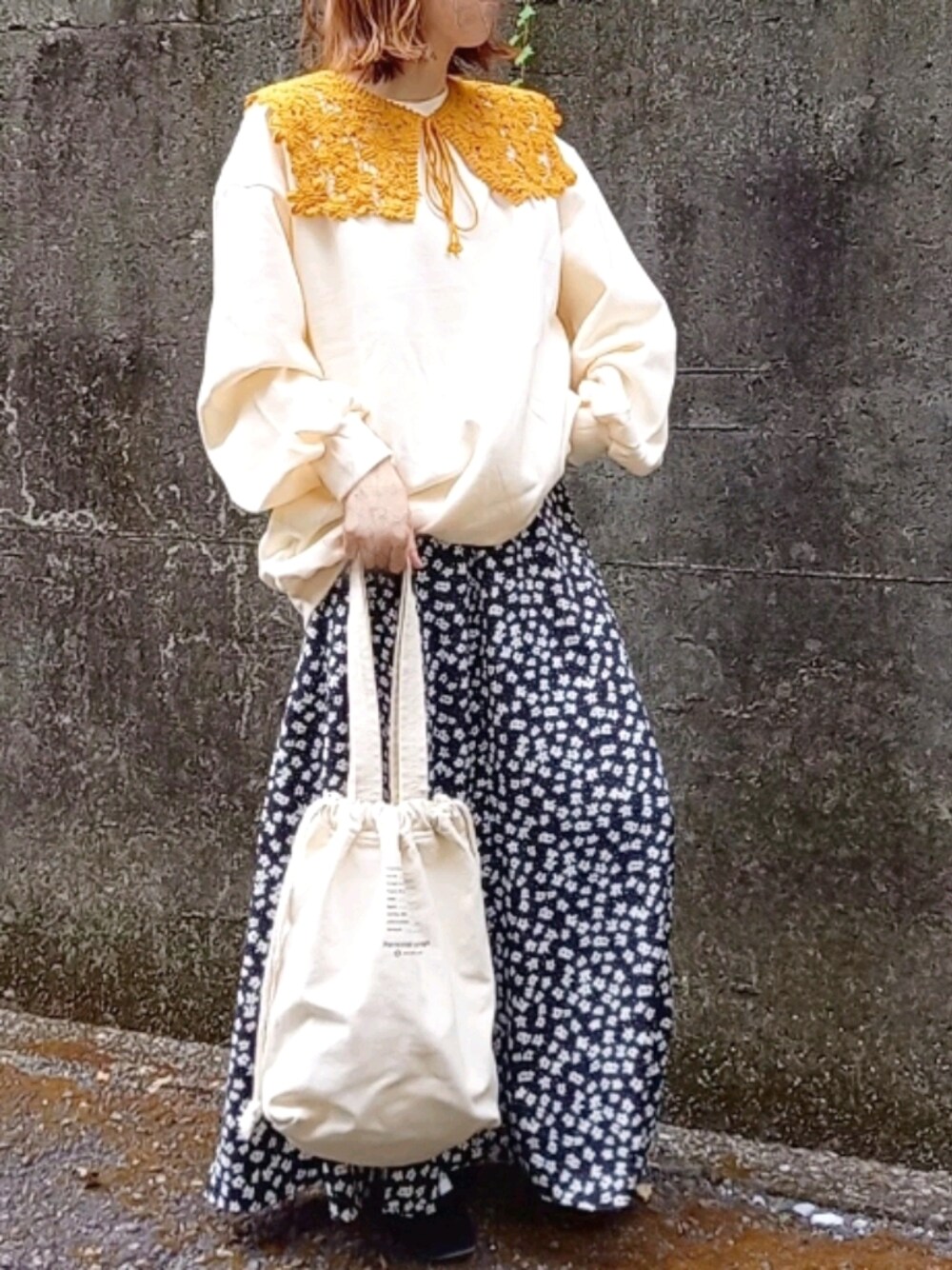 ブラック系のパンプス、ホワイト系のトートバッグ、ブラック系のスカートを着用したレディースの秋コーディネートの1枚目の写真