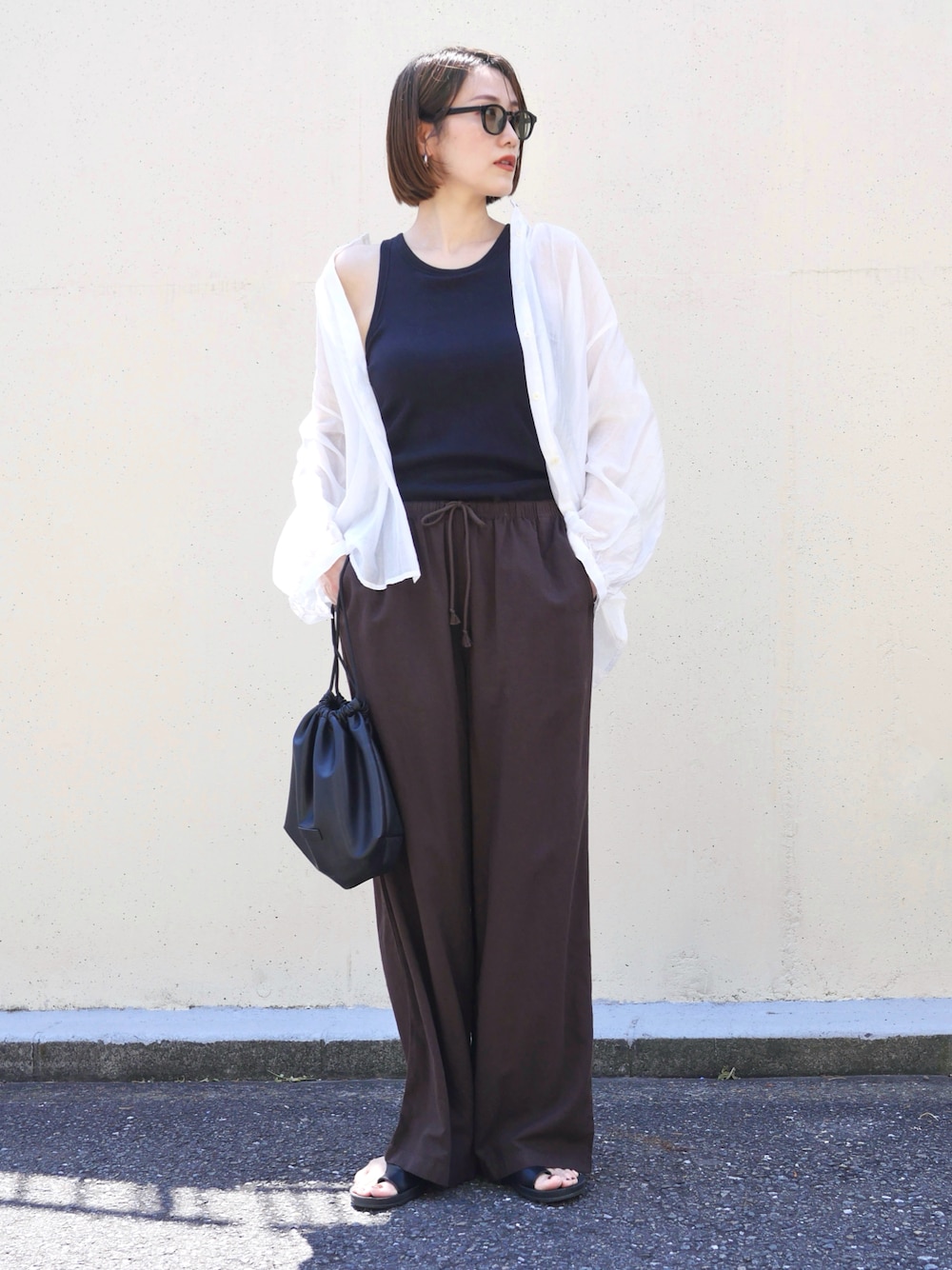 ホワイト系のシャツ/ブラウス、ブラック系のショルダーバッグ、ブラック系のサンダルを着用したレディースの夏コーディネートの1枚目の写真