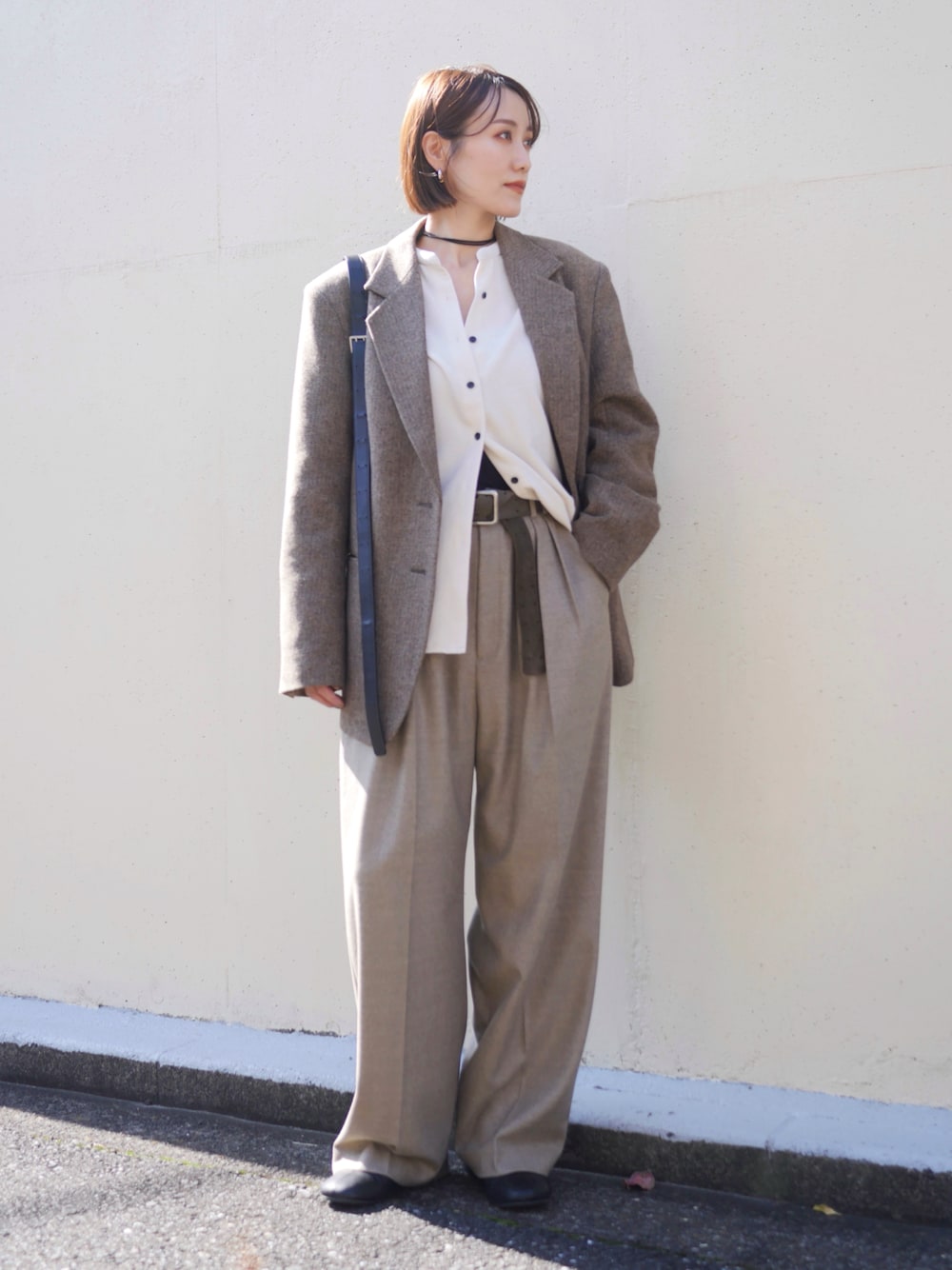 ベージュ系のテーラードジャケット、ベージュ系のその他パンツ、ブラック系のショルダーバッグを着用したレディースの秋コーディネートの1枚目の写真