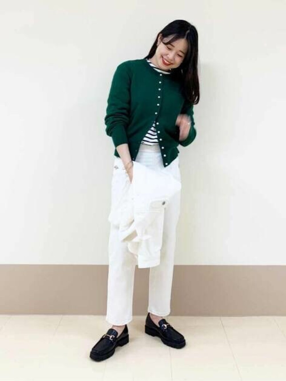 ブラック系のTシャツ/カットソー、ブラック系のローファー、ホワイト系のデニムパンツを着用したレディースの冬コーディネートの1枚目の写真