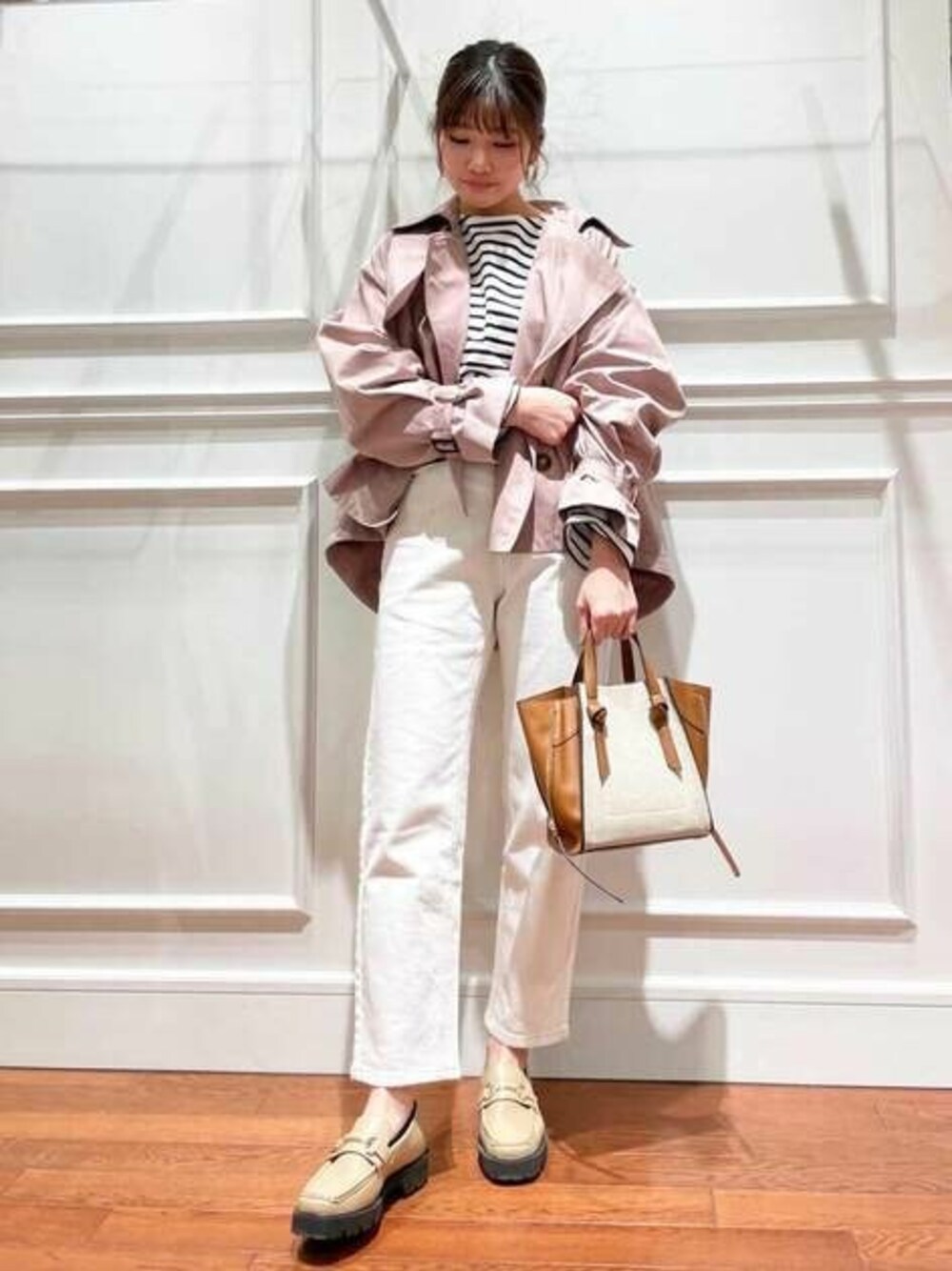 ホワイト系のデニムパンツ、ベージュ系のローファー、ブラック系のTシャツ/カットソーを着用したレディースの冬コーディネートの1枚目の写真