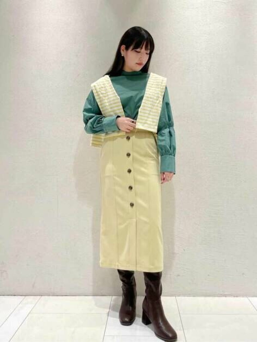 グリーン系のシャツ/ブラウス、イエロー系のTシャツ/カットソー、イエロー系のスカートを着用したレディースの冬コーディネートの1枚目の写真