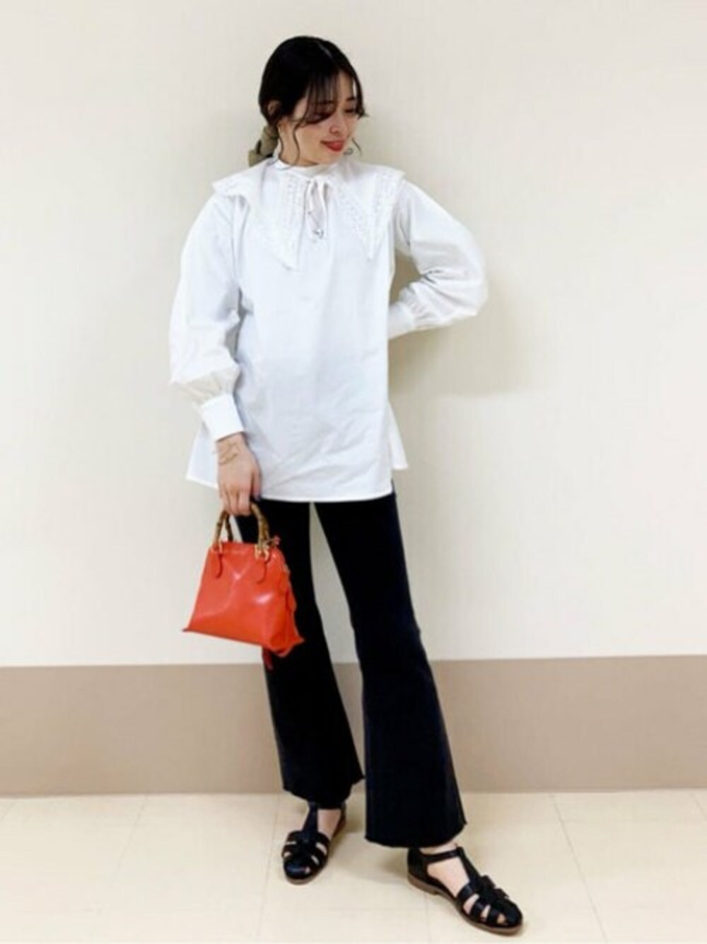 ブラック系のデニムパンツ、オレンジ系のショルダーバッグ、ホワイト系のTシャツ/カットソーを着用したレディースの春コーディネートの1枚目の写真