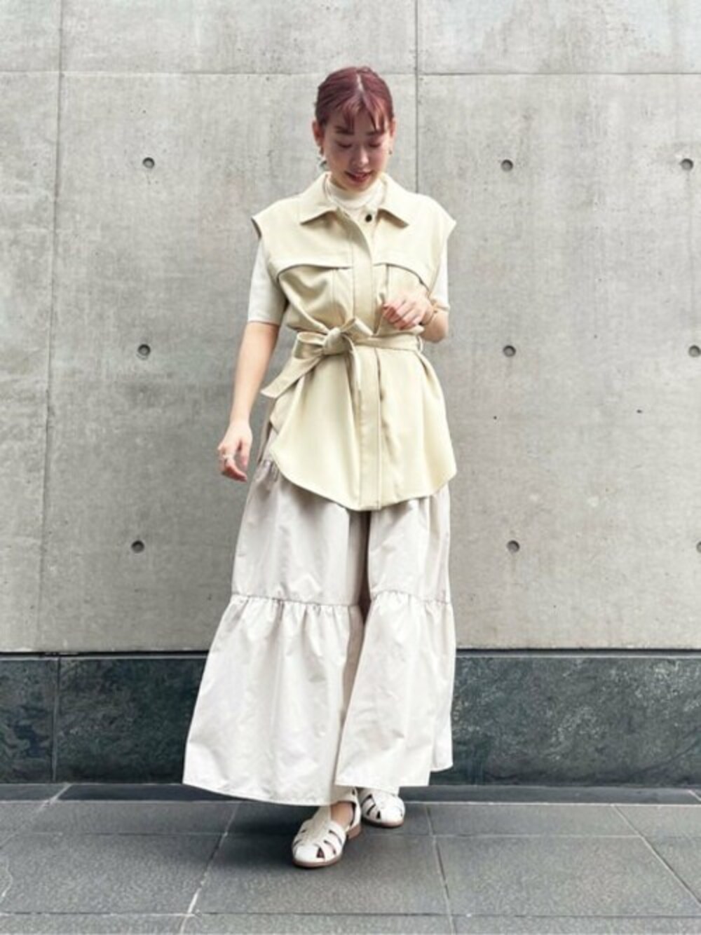 イエロー系のその他アウター、ベージュ系のスカート、ベージュ系のニット/セーターを着用したレディースの春コーディネートの1枚目の写真