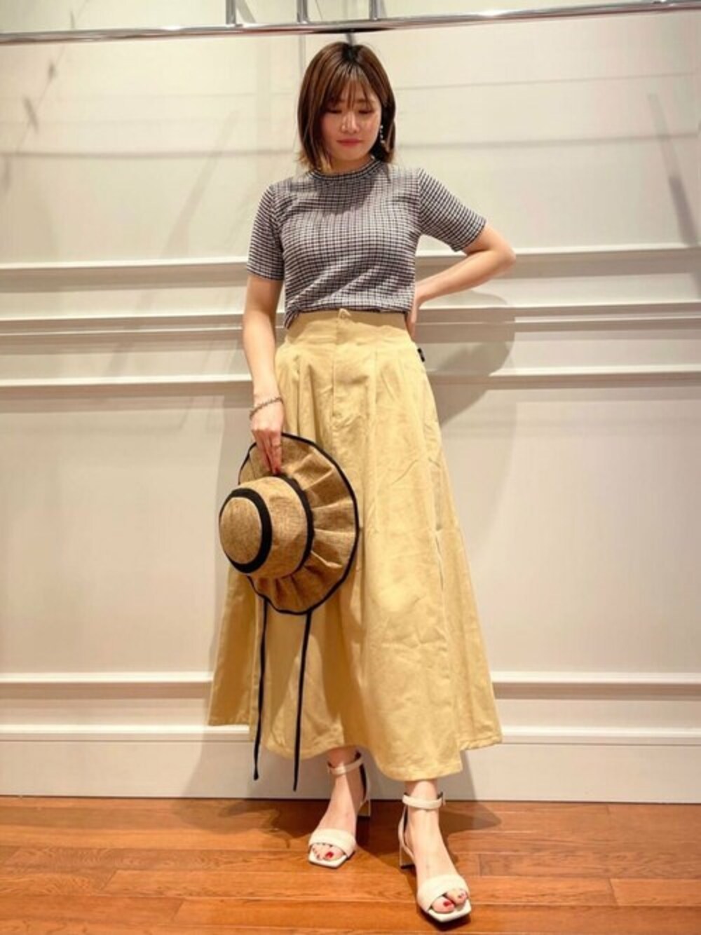 ブラック系のTシャツ/カットソー、ホワイト系のサンダル、ベージュ系のスカートを着用したレディースの春コーディネートの1枚目の写真