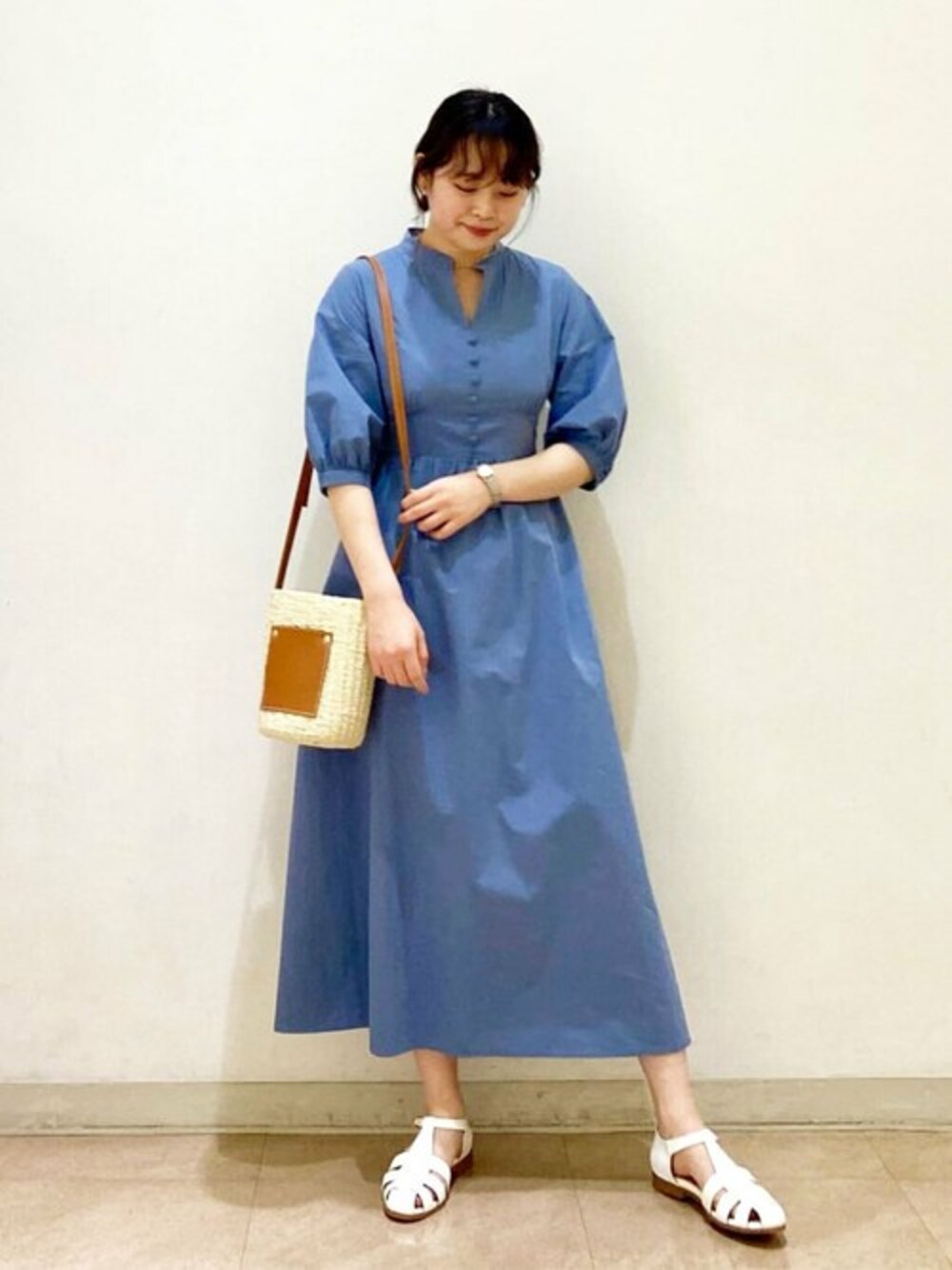 ブルー系のワンピース、ホワイト系のサンダル、ベージュ系のトートバッグを着用したレディースの春コーディネートの1枚目の写真