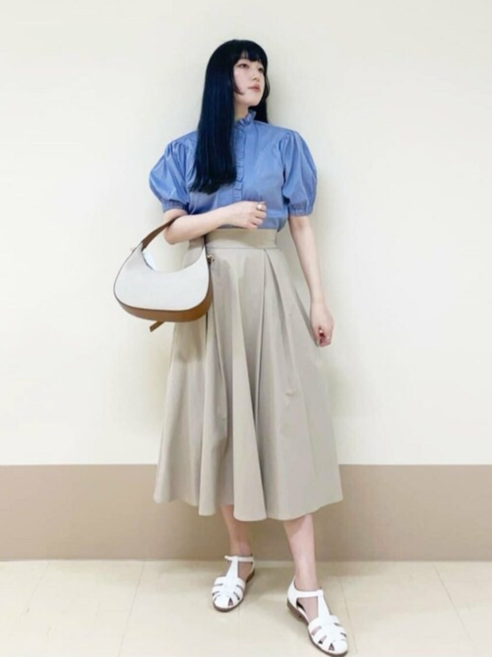 ブルー系のシャツ/ブラウス、ベージュ系のスカート、ブラウン系のショルダーバッグを着用したレディースの春コーディネートの1枚目の写真
