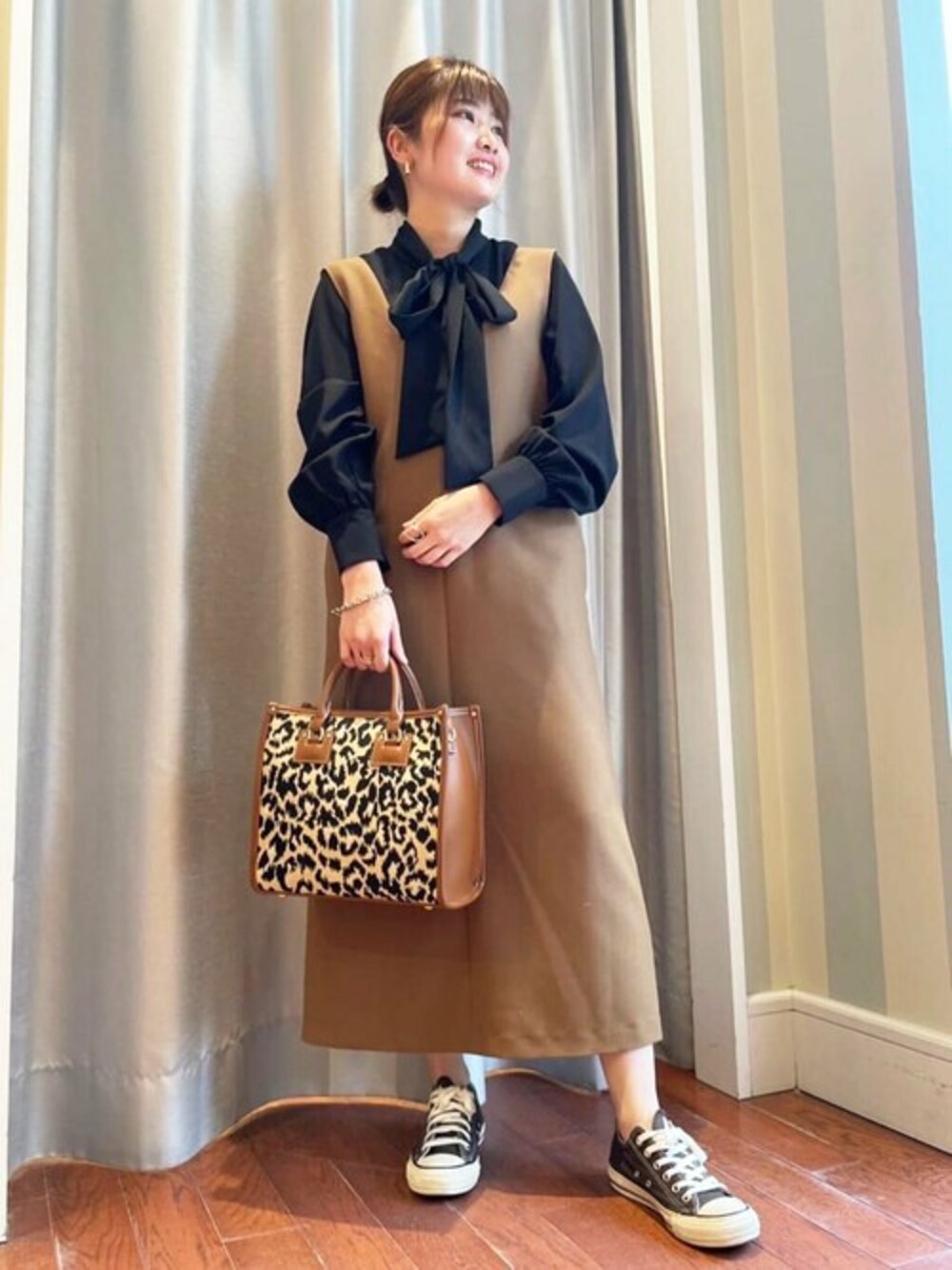 ブラック系のシャツ/ブラウス、ブラウン系のジャンパースカート、オレンジ系のトートバッグを着用したレディースの夏コーディネートの1枚目の写真