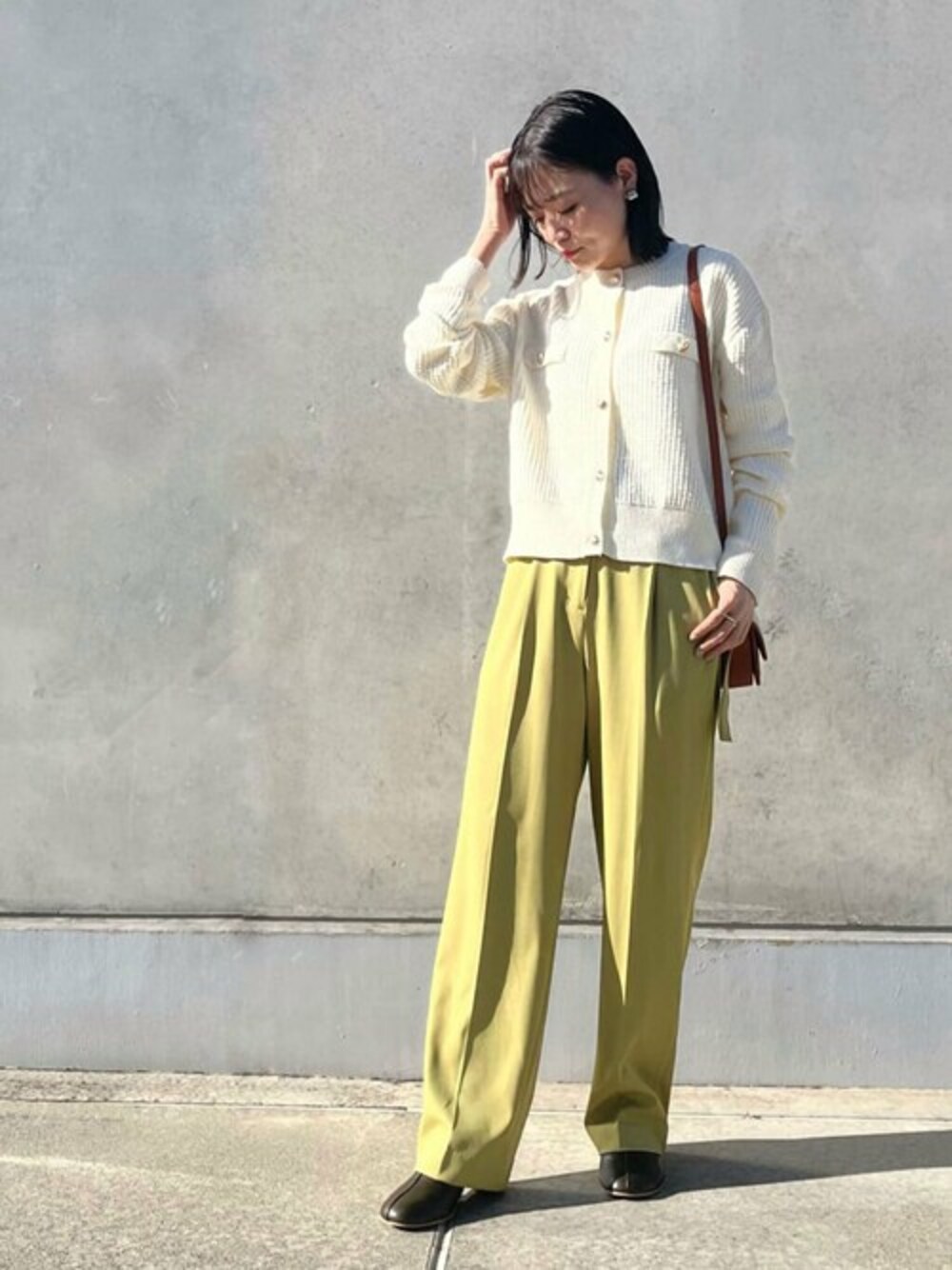 ホワイト系のカーディガン/ボレロ、イエロー系のその他パンツ、グリーン系のブーツを着用したレディースの秋コーディネートの1枚目の写真