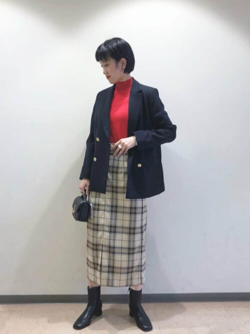 レッド系のニット/セーター、ブルー系のテーラードジャケット、ブラック系のショルダーバッグを着用したレディースの秋コーディネートの1枚目の写真