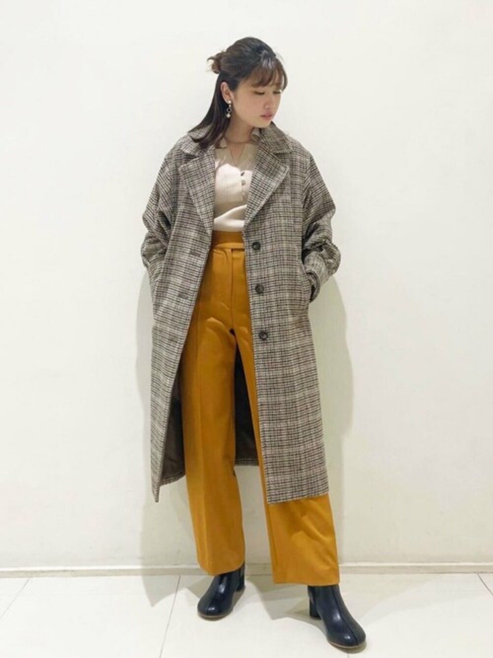 イエロー系のその他パンツ、ベージュ系のニット/セーター、その他のチェスターコートを着用したレディースの秋コーディネートの1枚目の写真