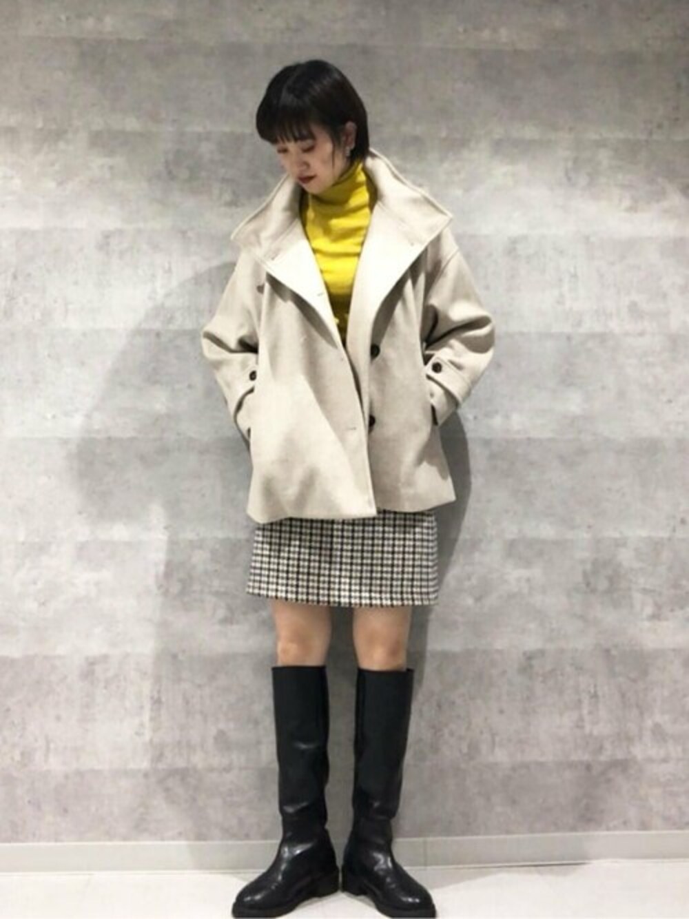 ベージュ系のその他アウター、ブラック系のブーツ、ブルー系のスカートを着用したレディースの秋コーディネートの1枚目の写真