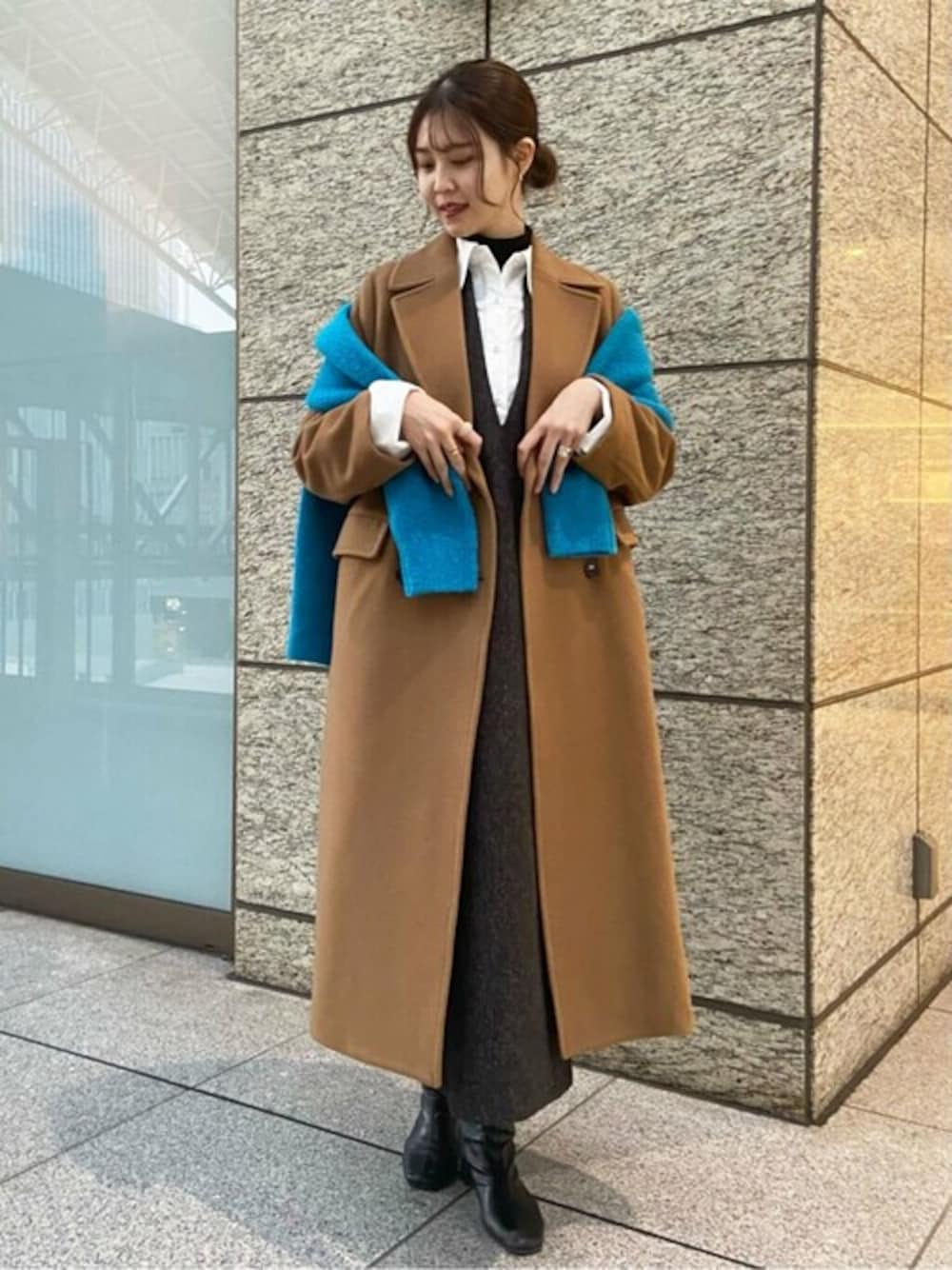 ブルー系のカーディガン/ボレロ、イエロー系のチェスターコート、ブラック系のジャンパースカートを着用したレディースの秋コーディネートの1枚目の写真