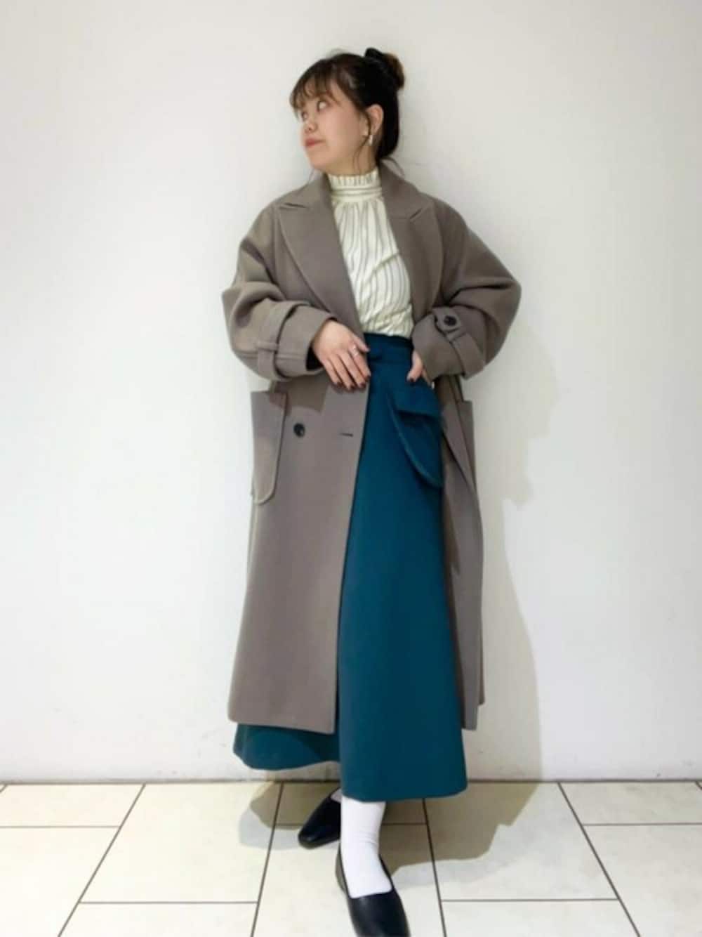 グリーン系のスカート、ホワイト系のシャツ/ブラウス、ブラウン系のチェスターコートを着用したレディースの冬コーディネートの1枚目の写真