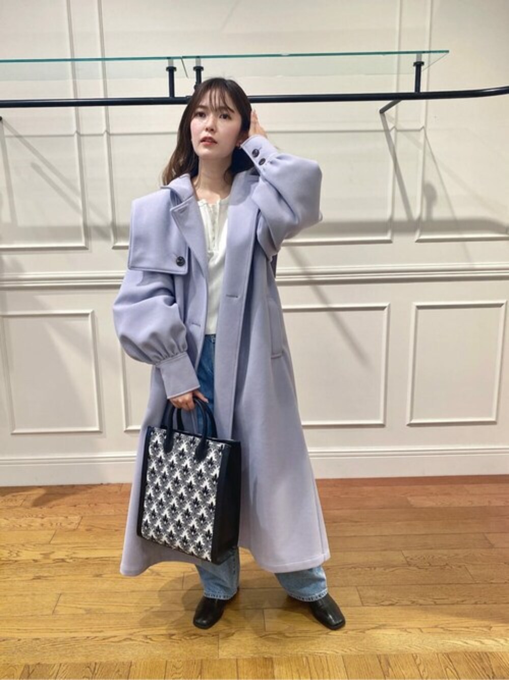 ホワイト系のニット/セーター、パープル系のステンカラーコートを着用したレディースの冬コーディネートの1枚目の写真