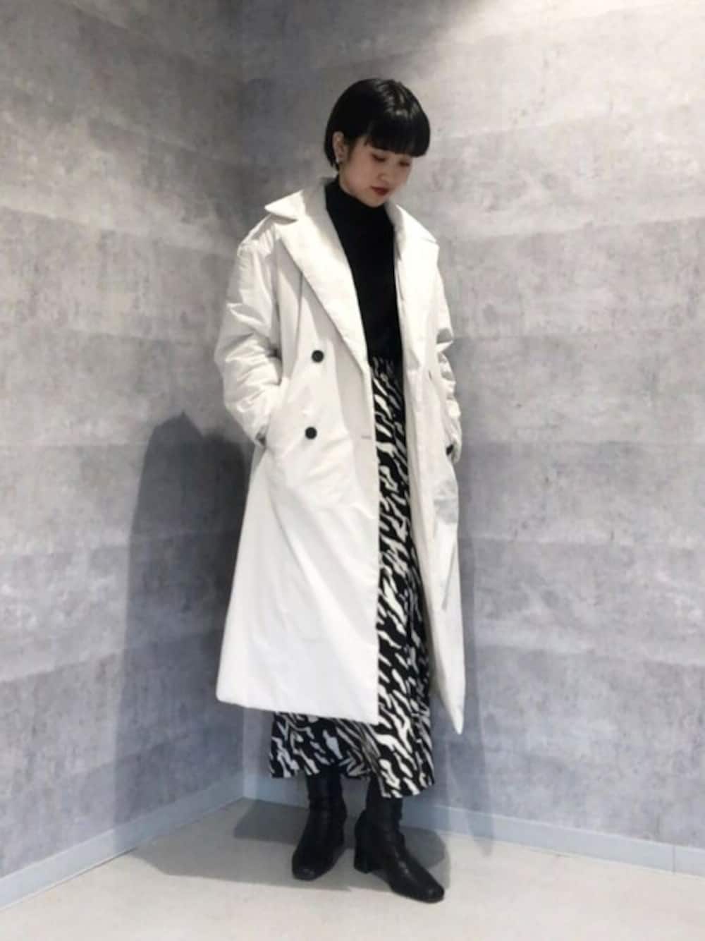 ホワイト系のその他アウター、ブラック系のスカート、ブラック系のニット/セーターを着用したレディースの冬コーディネートの1枚目の写真