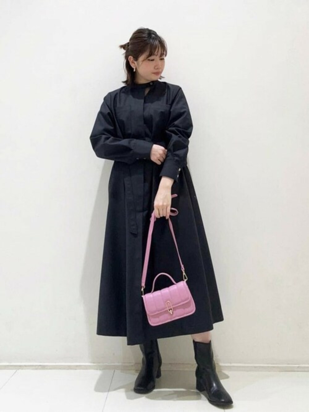 ピンク系のショルダーバッグ、グレー系のワンピース、ブラック系のブーツを着用したレディースの冬コーディネートの1枚目の写真