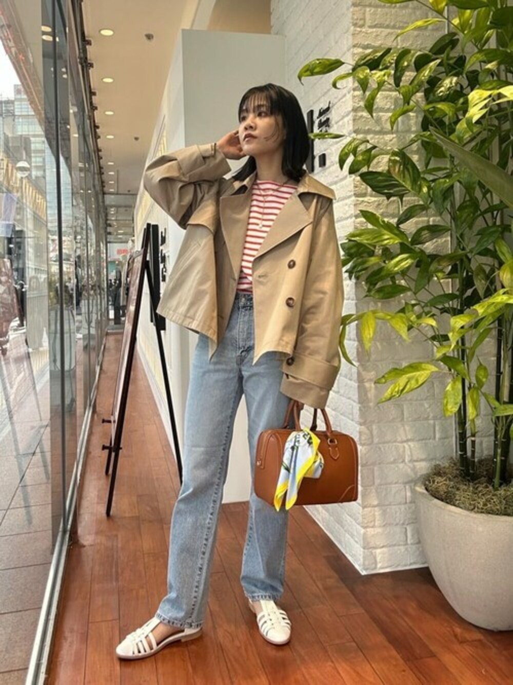 ブルー系のデニムパンツ、ホワイト系のサンダル、ホワイト系のTシャツ/カットソーを着用したレディースの冬コーディネートの1枚目の写真