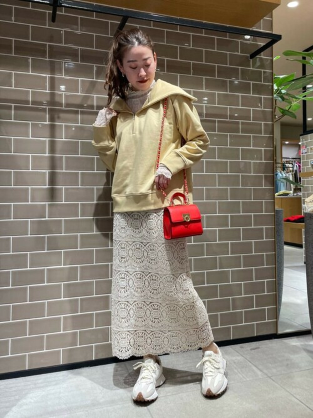 イエロー系のスウェット、ホワイト系のTシャツ/カットソー、ホワイト系のスカートを着用したレディースの冬コーディネートの1枚目の写真