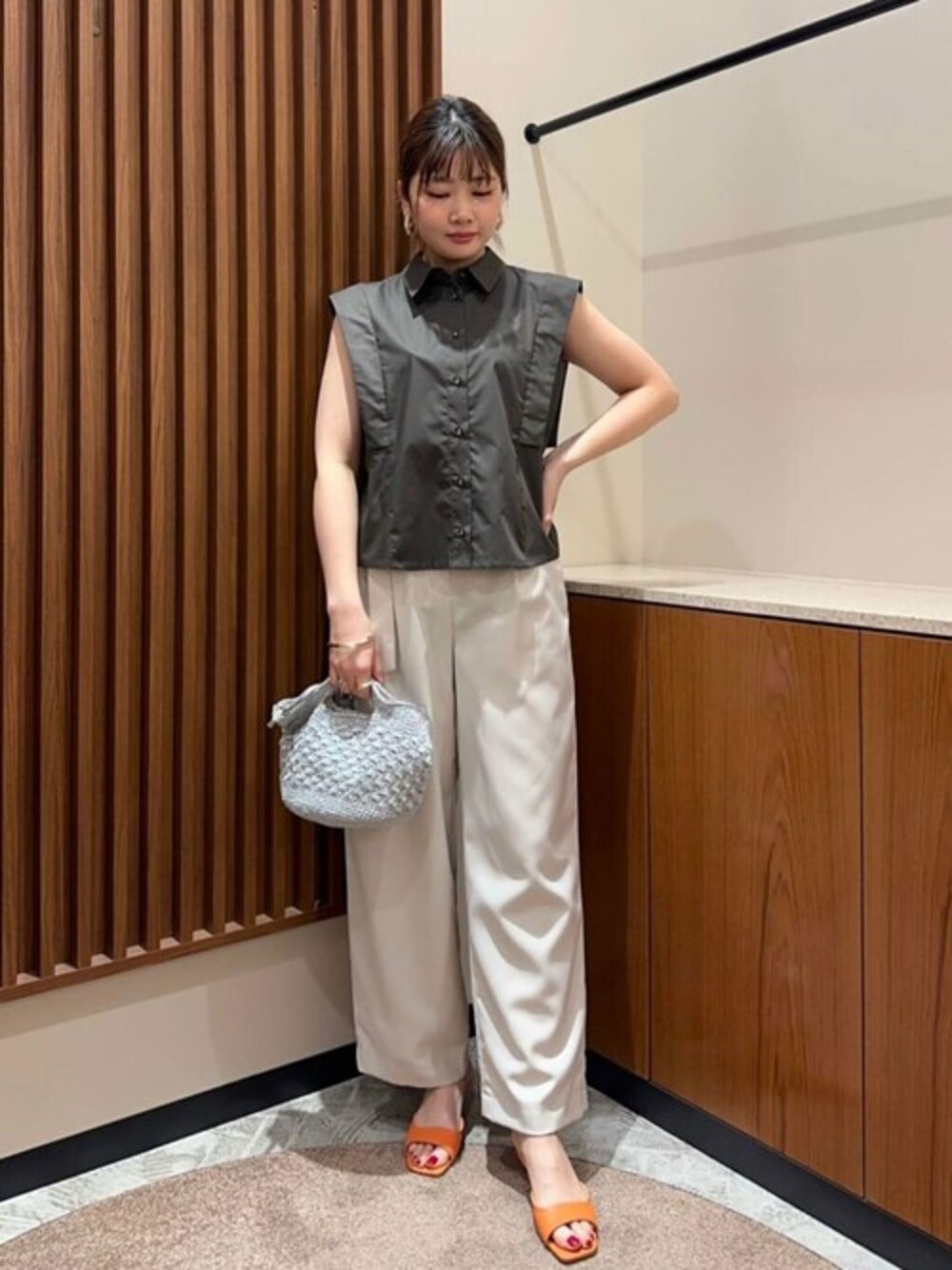 グレー系のシャツ/ブラウス、シルバー系のトートバッグ、オレンジ系のサンダルを着用したレディースの春コーディネートの1枚目の写真