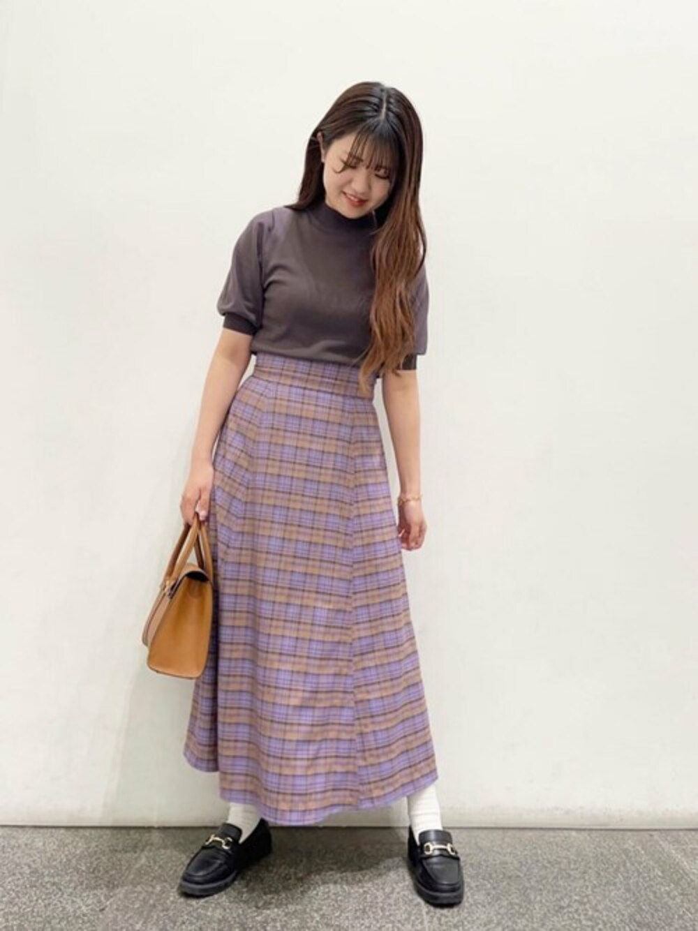 パープル系のスカート、ブラウン系のニット/セーター、ブラウン系のトートバッグを着用したレディースの春コーディネートの1枚目の写真