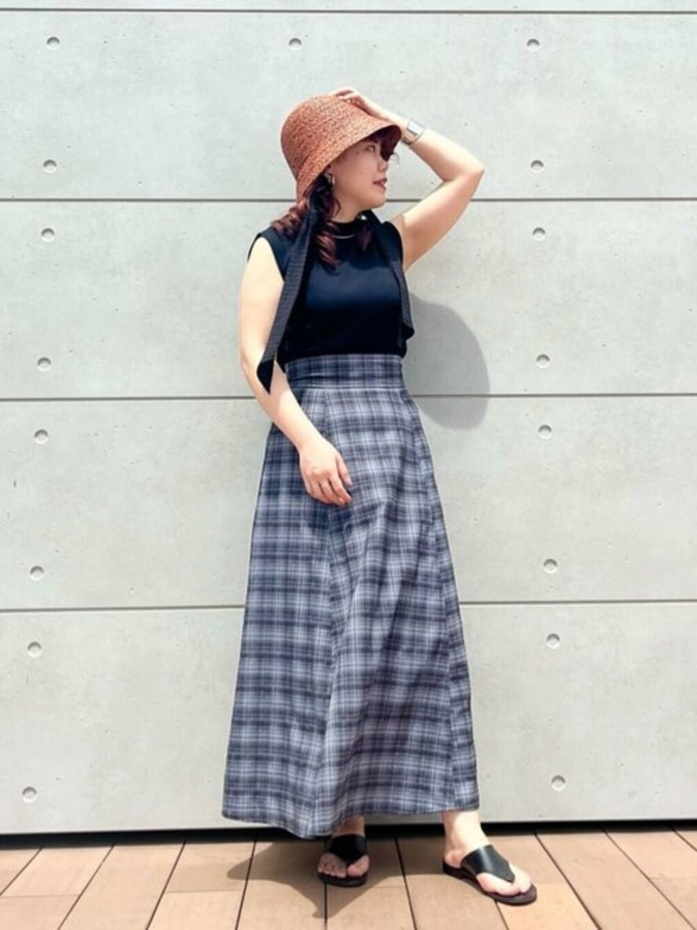 ブラック系のニット/セーター、ブラック系のスカート、ブラック系のショルダーバッグを着用したレディースの春コーディネートの1枚目の写真