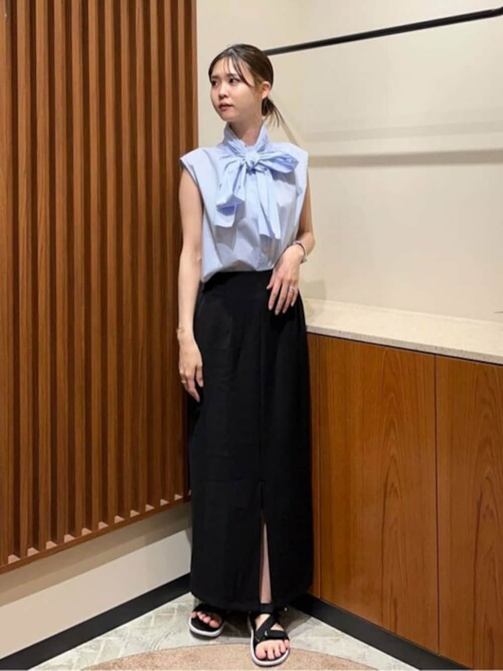 ブルー系のシャツ/ブラウス、ブラック系のスカートを着用したレディースの春コーディネートの1枚目の写真