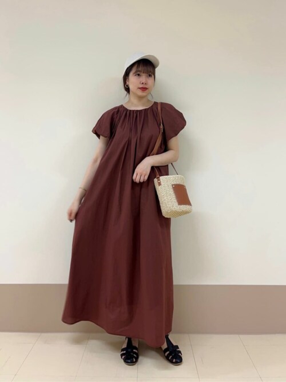 ブラウン系のワンピース、ブラック系のサンダル、ベージュ系のショルダーバッグを着用したレディースの夏コーディネートの1枚目の写真