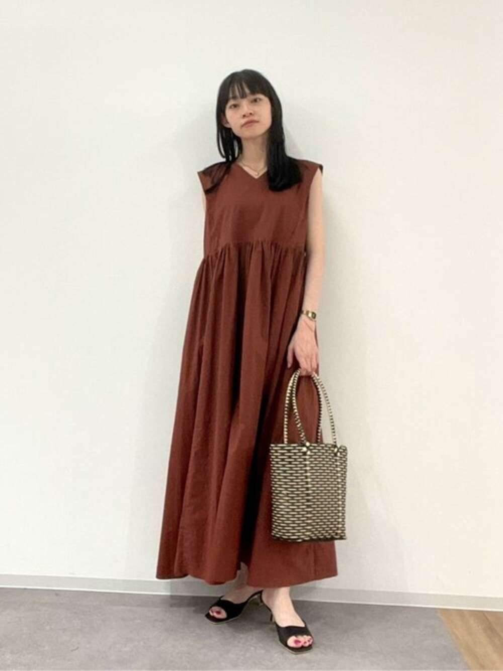 ブラウン系のワンピース、ブラック系のサンダルを着用したレディースの夏コーディネートの1枚目の写真