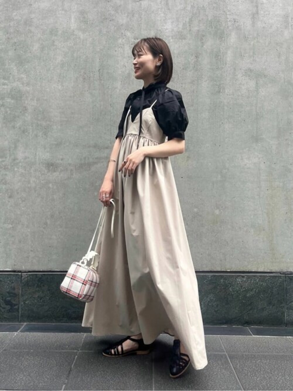 ブラック系のシャツ/ブラウス、ベージュ系のワンピース、ブラック系のサンダルを着用したレディースの夏コーディネートの1枚目の写真
