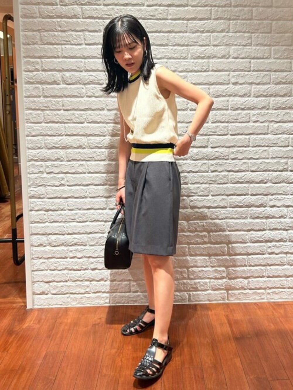 ホワイト系のニット/セーター、グレー系のその他パンツ、ブラック系のトートバッグを着用したレディースの夏コーディネートの1枚目の写真