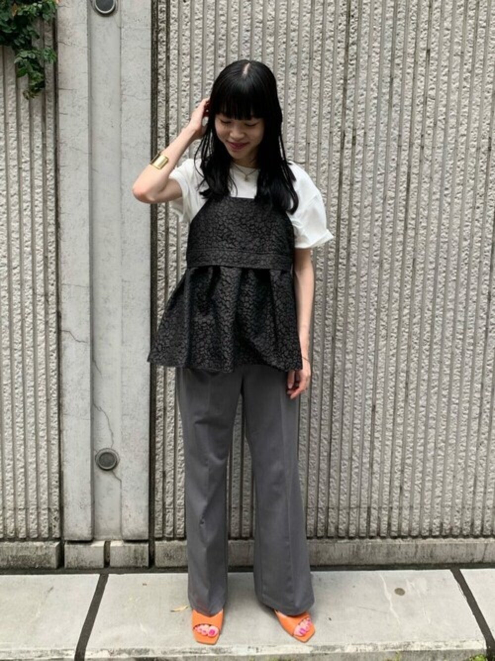 ブラウン系のシャツ/ブラウス、グレー系のスラックス、ホワイト系のTシャツ/カットソーを着用したレディースの夏コーディネートの1枚目の写真