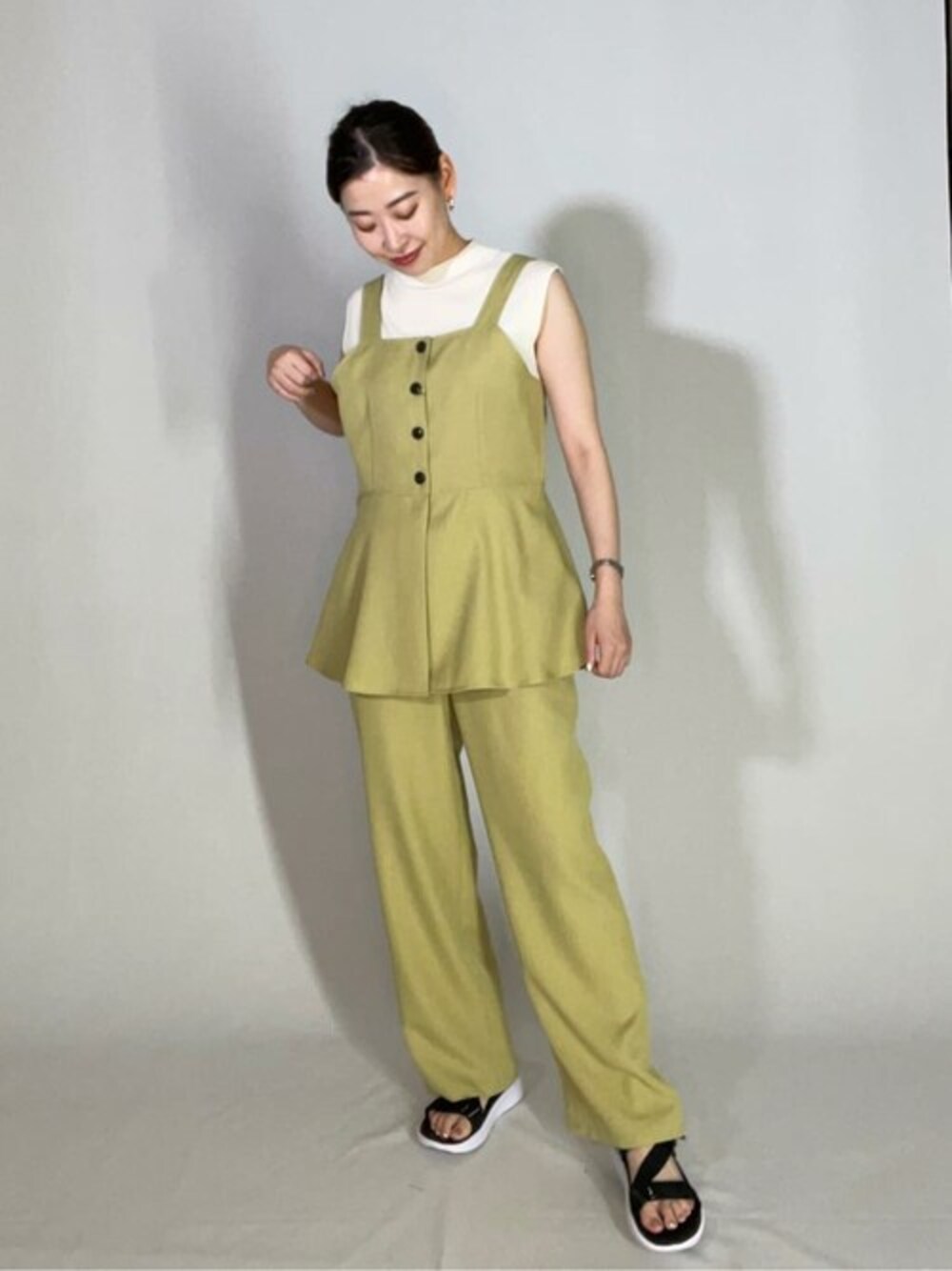 イエロー系のワンピース、ホワイト系のニット/セーターを着用したレディースの夏コーディネートの1枚目の写真