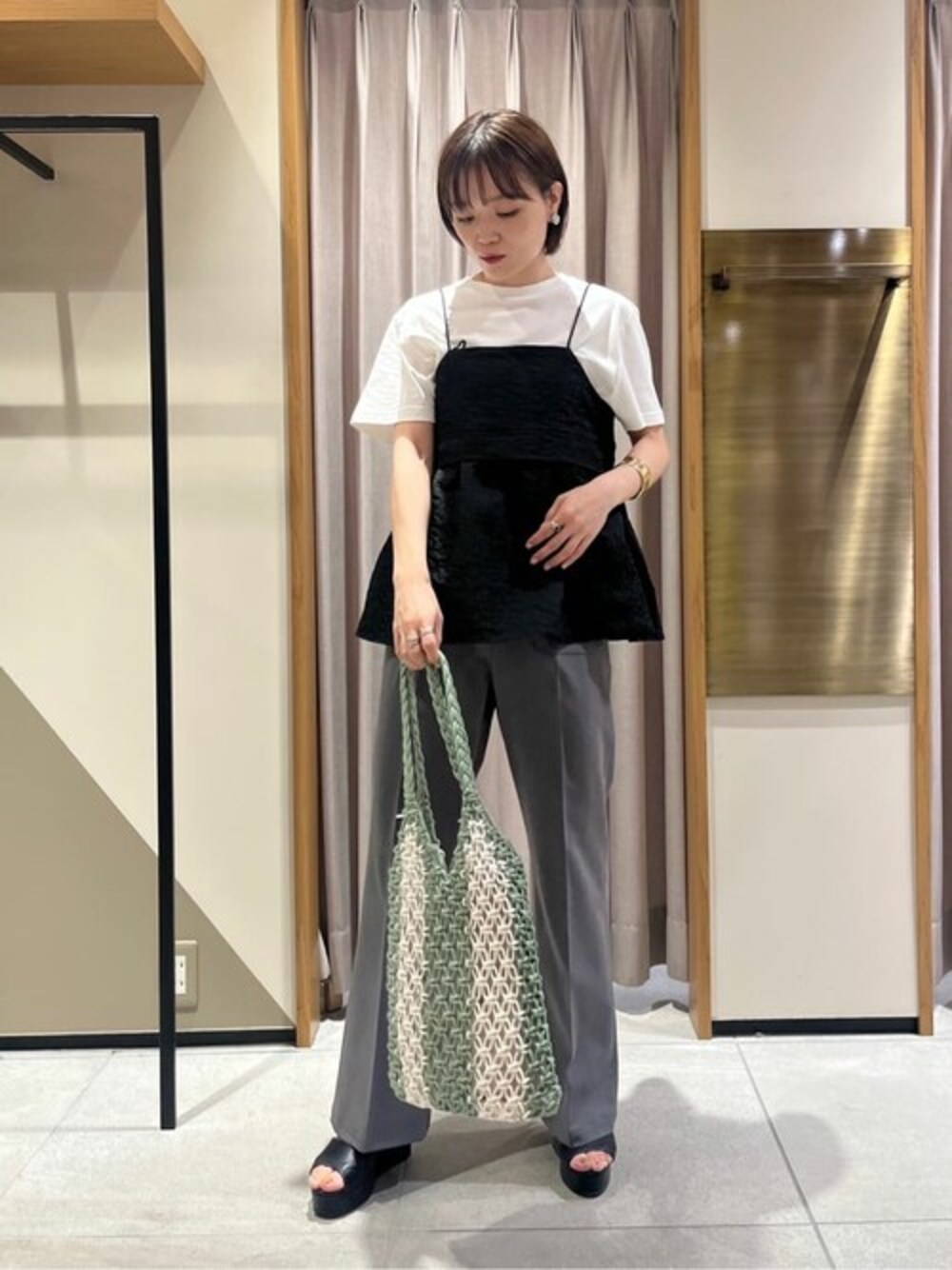 ブラック系のシャツ/ブラウス、グレー系のスラックス、ホワイト系のTシャツ/カットソーを着用したレディースの夏コーディネートの1枚目の写真