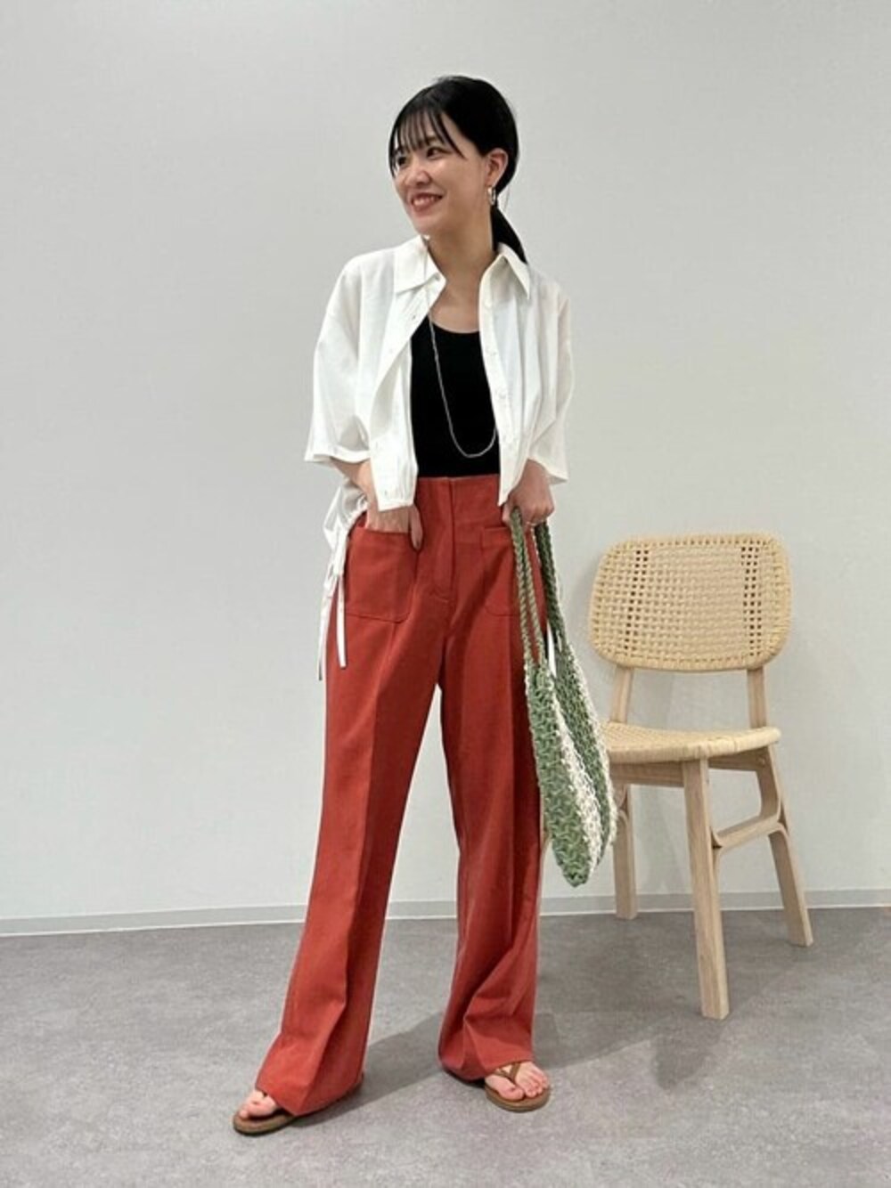 ホワイト系のシャツ/ブラウス、レッド系のスラックス、ブラック系のチューブトップを着用したレディースの夏コーディネートの1枚目の写真