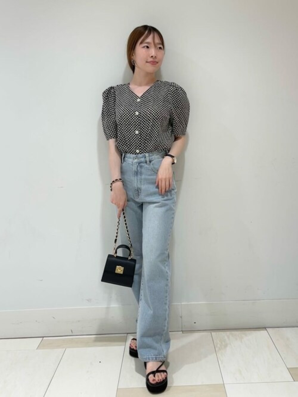 ブラック系のシャツ/ブラウス、ブルー系のデニムパンツ、ブラック系のビジネスバッグを着用したレディースの夏コーディネートの1枚目の写真